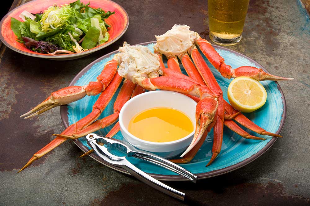 A pair of Clusters of Steamed Snow Crab Legs Served with Butter
