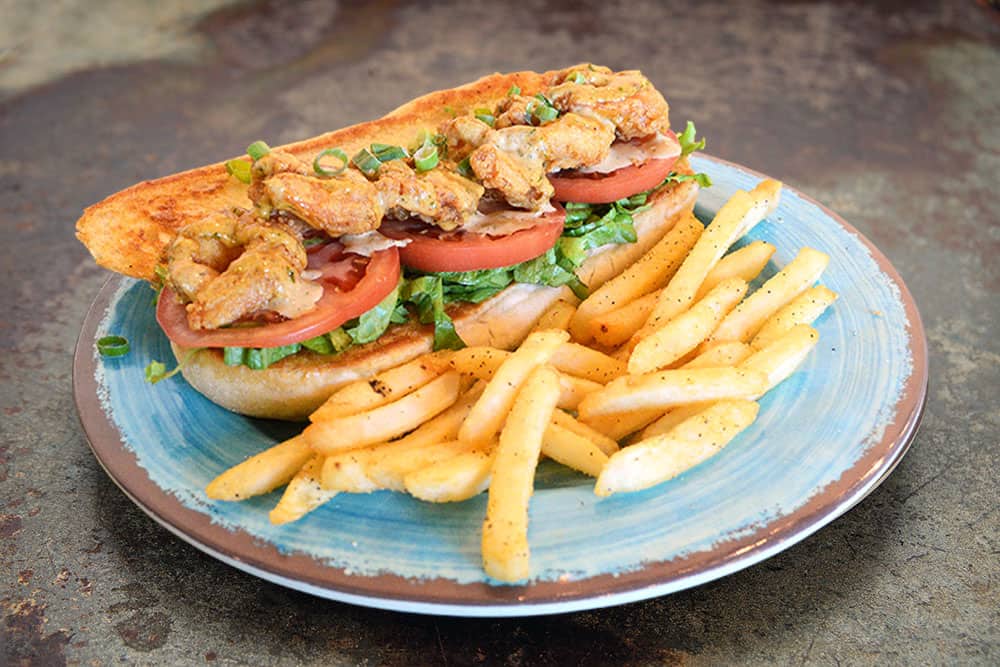Shrimp Po Boy A pile of Large Shrimp, Good Ole Cajun Spicy Remoulade along with Shredded Lettuce and Tomato on Leidenheimer French Bread