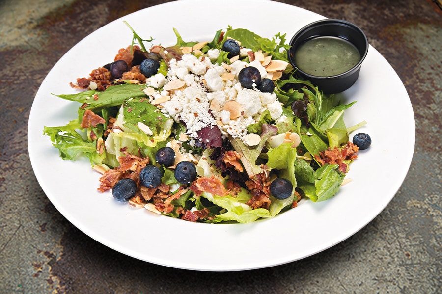 Our House Salad Featuring Romaine and Seasonal Greens, Tossed in Sweet Onion Dressing, Topped with Crumbled Goat Cheese, Bacon, Sliced Almonds & Fresh Berries – Add Chicken, or Shrimp