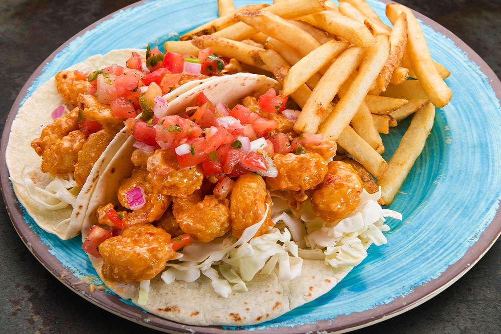 Crispy Fried Popcorn Shrimp tossed in our Spicy Creamy Sauce, Shredded Cabbage, and Fresh Pico de Gallo